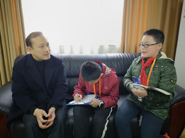 九龙坡区实验一小何军校长就家委会会议与学生展开交流。（彭材露 摄）.jpg