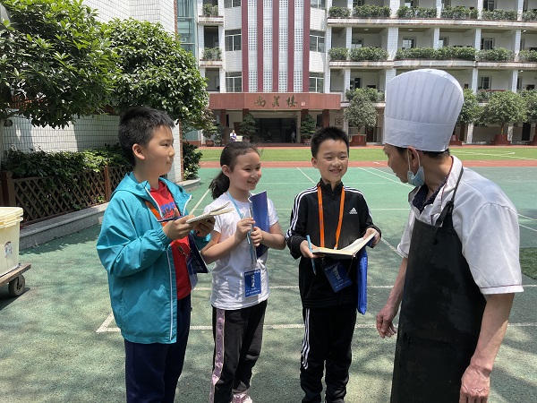 学生采访食堂工作人员。.jpg