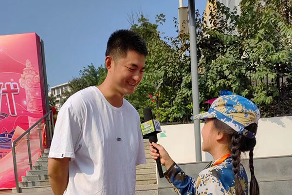 活动现场，一位老师向小记者分享他感受到的校园变化。.jpg