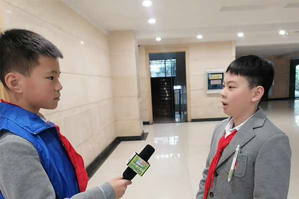 红领巾小记者们覃奕然和现场的少代会代表交流。.jpg